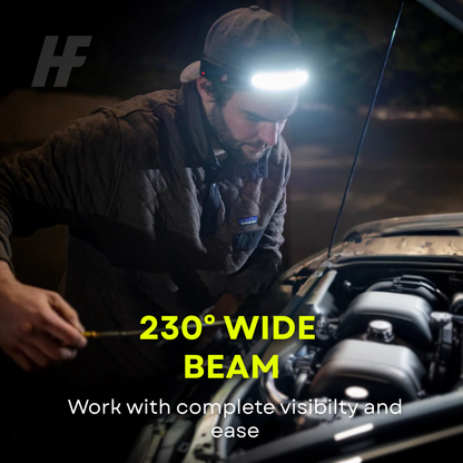 Man wearing a HaloFlex LED headlamp at night leaning over an open car engine bay, illuminated by the headlamp's bright 230-degree wide beam, with text reading 230 Degree Wide Beam - Work with complete visibility and ease